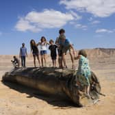 People climb on the debris of an Iranian missile intercepted by Israel, near Arad, southern Israel, on 2 October