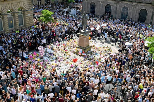 Members of the public observe a minute's silence in memory of the victims of the 2017 Manchester Arena bombing (Picture: Jeff J Mitchell)