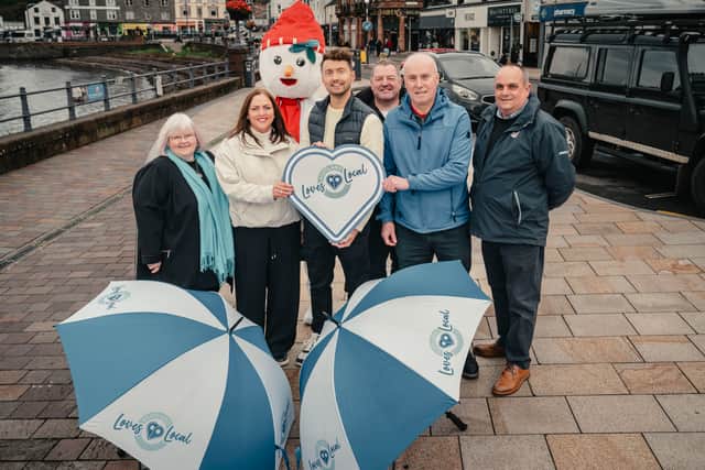TV presenter Sean Batty, centre, with Scotland's Towns Partnership chief officer Kimberley Guthrie to the left, and BID4Oban chair Tony Cave to the right, plus others from the community as they celebrate Oban being named Scotland's Town of the Year in the 2024 Scotland Loves Local Awards.