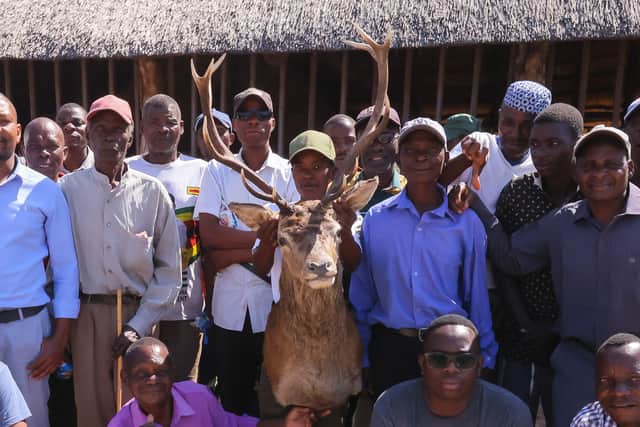 Community members pose for a photograph with a Stags head