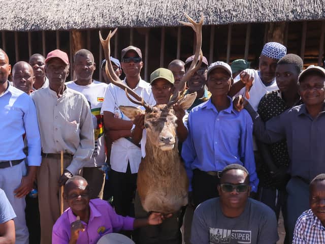 Community members pose for a photograph with a Stags head