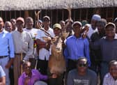 Community members pose for a photograph with a Stags head