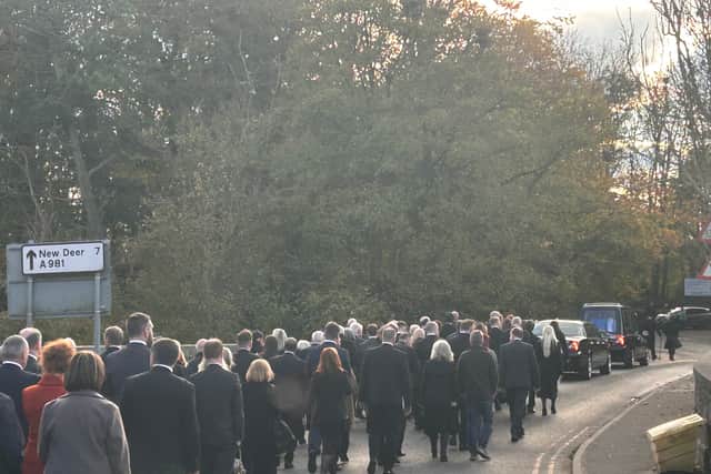 Mourners follow Mr Salmond's coffin to Strichen Cemetery following the church service.