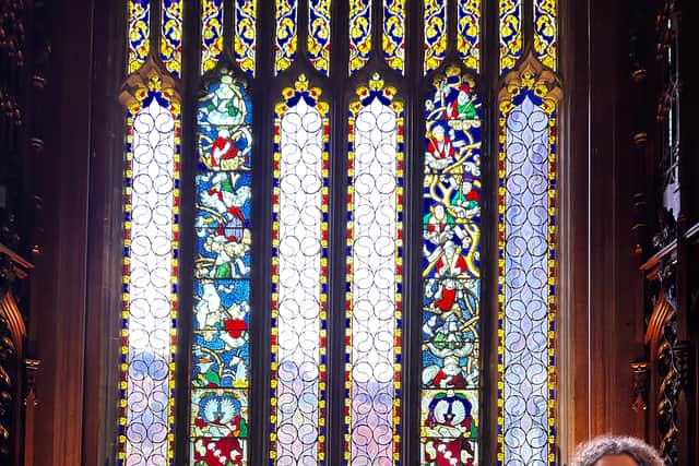 Moira Malcolm, of Rainbow Glass Studio, with the restored 16th Century window.