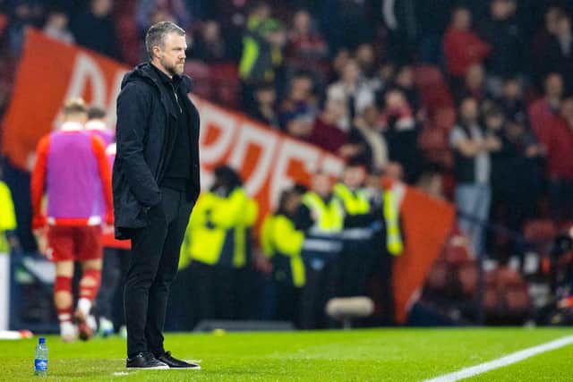 Aberdeen manager Jimmy Thelin watches on.