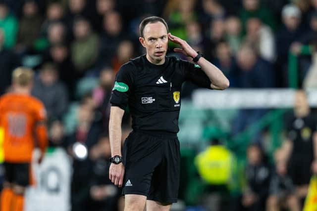 Referee Colin Steven talks to his VAR assistant before awarding Dundee United a late penalty at Easter Road. Cr: SNS Group.