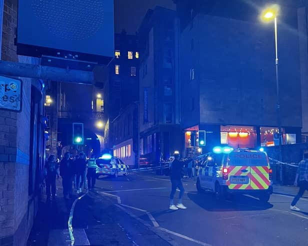 Emergency personnel in the Cowgate area of Edinburgh where a 74-year-old man died after being struck by a single decker bus. Picture: Roy/PA Wire