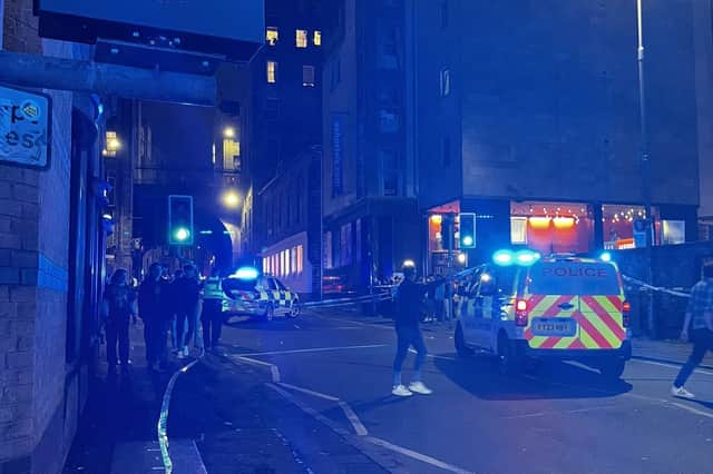 Emergency personnel in the Cowgate area of Edinburgh where a 74-year-old man died after being struck by a single decker bus. Picture: Roy/PA Wire