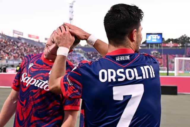 Lewis Ferguson celebrates Bologna's win with goal scorer Riccardo Orsolini. Cr: Getty Images.