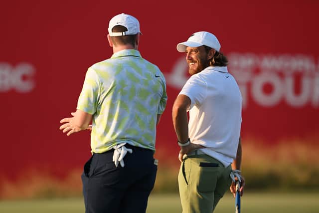 Leader Tommy Fleetwood laughs about something playing partner Bob MacIntyre has to say at Yas Links.