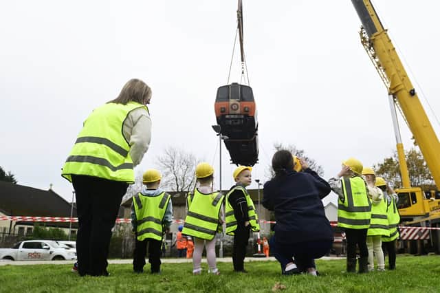 Children at the Ivy In The Park childcare centre in the Carntyne area of Glasgow watch the arrival of a former Glasgow Subway carriage on November 8