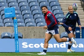 Sione Tuipulotu passes out the back to Dylan Richardson during a Scotland training session at Scottish Gas Murrayfield.