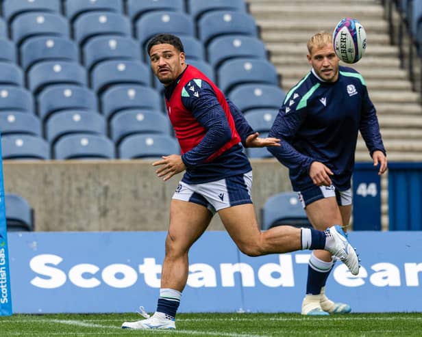 Sione Tuipulotu passes out the back to Dylan Richardson during a Scotland training session at Scottish Gas Murrayfield.