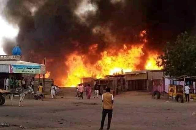A man watches as a fire rages in a livestock market in al-Fasher, the capital of Sudan's North Darfur state, following an attack by the Rapid Support Forces