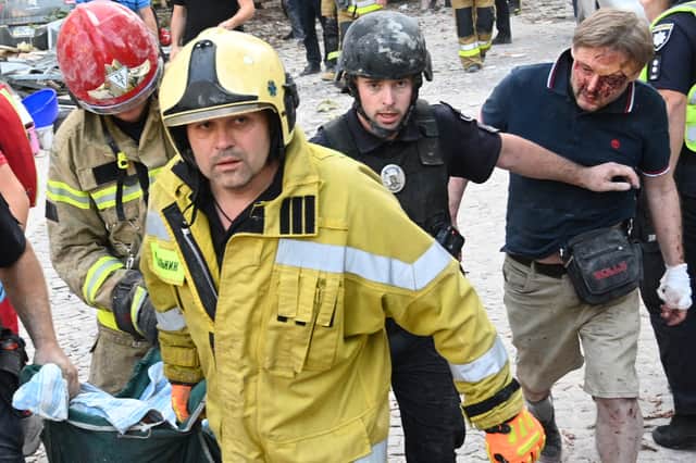 Jaroslav Bazylevych, right, follows emergency services staff carrying the body of his daughter, who was killed along with her two sisters and their mother during a Russian missile attack in Lviv in September (Picture: Yuriy Dyachyshyn)