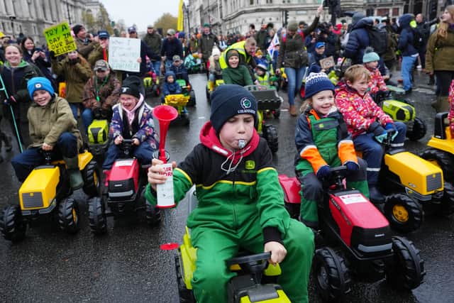 Young guns ride toy tractors through Parliament Square