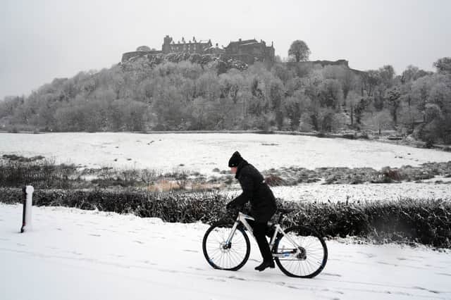 A person rides a bicycle in the snow at Stirling Castle.