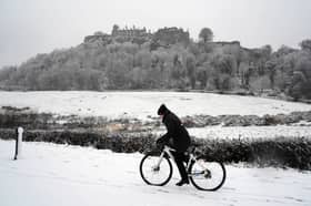 A person rides a bicycle in the snow at Stirling Castle.