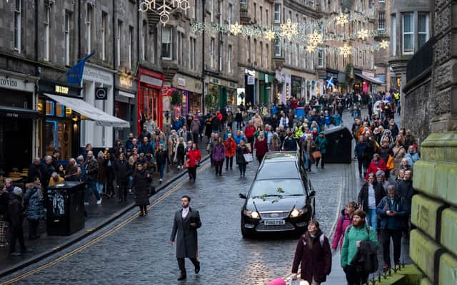 People line the streets as Scottish comedian Janey Godley's hearse travels through Edinburgh