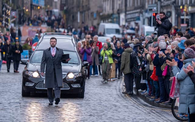 People line the streets as Scottish comedian Janey Godley's hearse travels through Edinburgh on its way to her funeral service, which will be held at St Mary's Cathedral in Glasgow on Saturday