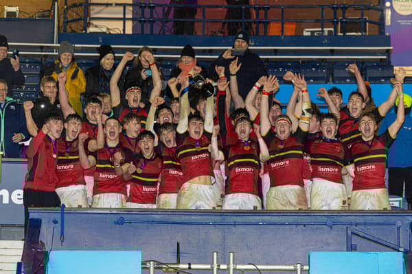 Stewart's Melville College players celebrate with the trophy at full time after the 2024 Boys' Schools Cup Final win over Merchiston Castle. (Photo by Mark Scates / SNS Group)