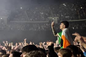A fan pops up on a friend's shouders to take a picture.