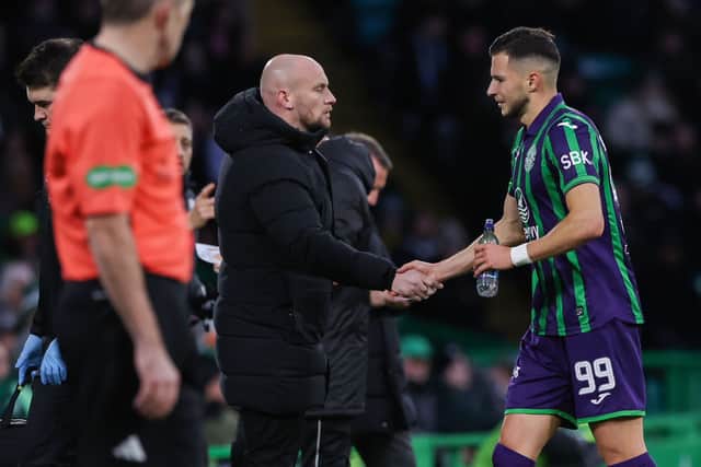 Hibs head coach David Gray shakes Kuharevich's hand as he comes off injured.