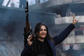 A Syrian Kurd in the city of Qamishli celebrates the fall of capital Damascus to rebel forces (Picture: Delil Souleiman)