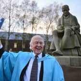 Professor Peter Higgs poses in front of a statue of James Watt after receiving an honorary degree of doctor of science from Heriot-Watt University, Edinburgh, in 2012