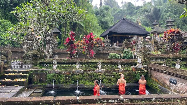 Visitors participating in a purification ceremony after making an offering at the Gunung Kawi Sebatu Hindu temple.