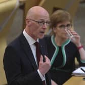 John Swinney, with former first minister Nicola Sturgeon looking on