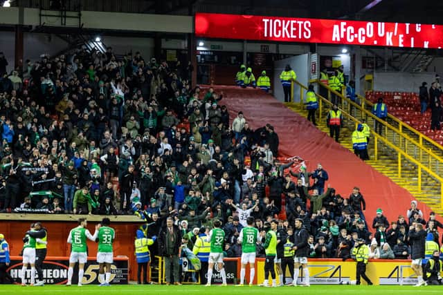 The Hibs fans celebrate in front of the joyous away support at Pittodrie.