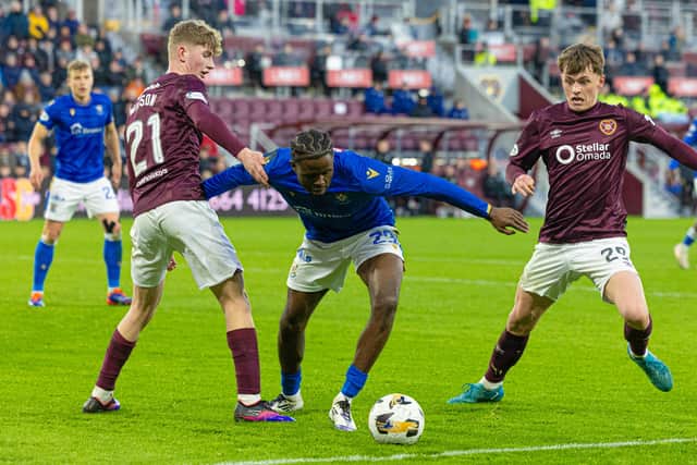 Hearts' James Wilson (L) and James Penrice (R) and St Johnstone's Benjamin Kimpioka in action at Tynecastle.