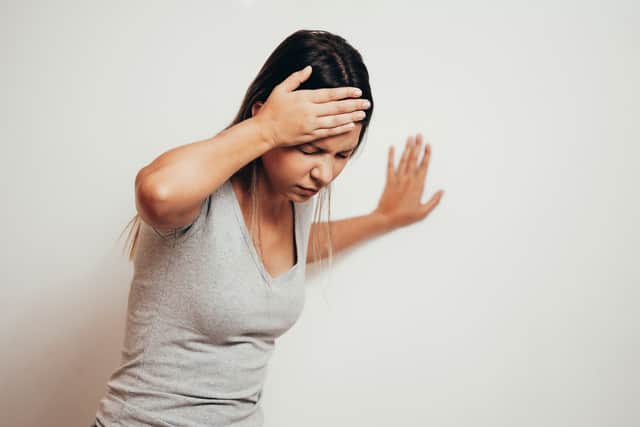 Dizzy person leaning against wall