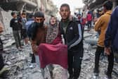 An injured woman is carried away after an Israeli strike in Gaza City's Sabra neighbourhood earlier this month (Picture: Omar al-Qattaa)
