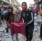 An injured woman is carried away after an Israeli strike in Gaza City's Sabra neighbourhood earlier this month (Picture: Omar al-Qattaa)