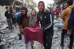 An injured woman is carried away after an Israeli strike in Gaza City's Sabra neighbourhood earlier this month (Picture: Omar al-Qattaa)