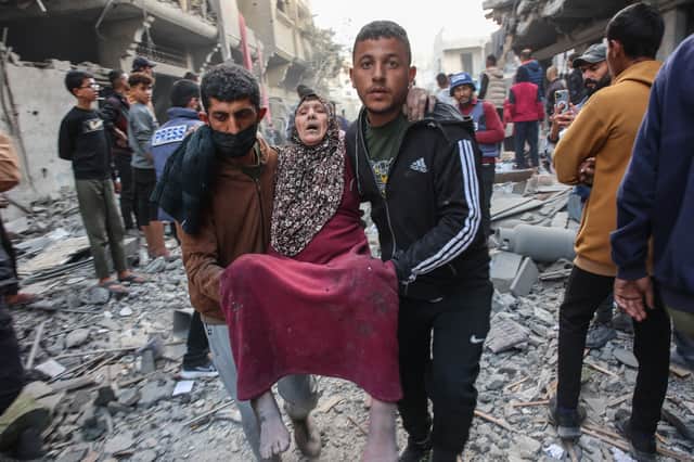 An injured woman is carried away after an Israeli strike in Gaza City's Sabra neighbourhood earlier this month (Picture: Omar al-Qattaa)