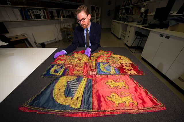 Senior Curator Dr Calum Robertson and the tabard, which has been purchased for the national collection.