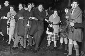 People singing Auld Lang's Syne during New Year at the Tron, Edinburgh 1964. The Scots have long regarded Hogmanay as the festive celebration of choice. 