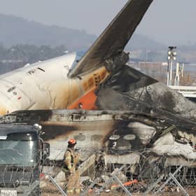 Firefighters check near the wreckage of a passenger plane at Muan International Airport