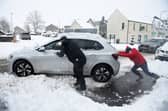 Stock image of car being pushed out of snow.