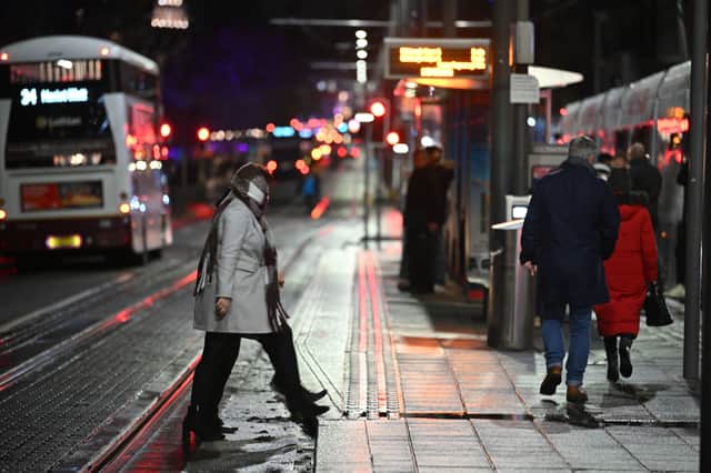 People on a near-deserted Princes Street in Edinburgh after all outdoor Hogmanay events including the street party and fireworks display were cancelled due to bad weather. Picture: Andy Buchanan/PA Wire 