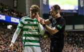 Referee Don Robertson checks on the condition of Celtic midfielder Arne Engels after he was struck with a coin thrown by a Rangers fan.