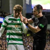 Referee Don Robertson checks on the condition of Celtic midfielder Arne Engels after he was struck with a coin thrown by a Rangers fan.