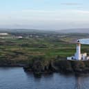 Trump Turnberry with the remains of Turnberry Castle on the promontory in the foreground, to the left of the lighthouse.