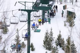 Bar up or bar down? Skiers ride a chairlift at Deer Valley Ski Resort in Park City, Utah, December 2022