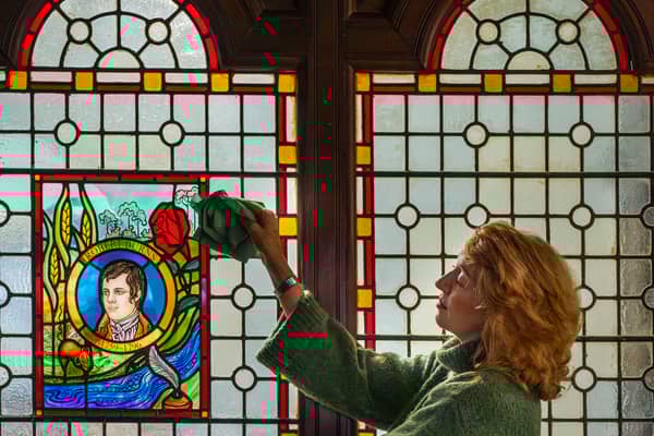 Fiona Lee is pictured with a stained glass window of Robert Burns inside St Michael's Church in Dumfries, which is seeking to raise £25,000 to protect and improve the building where the poet regularly attended Sunday service.