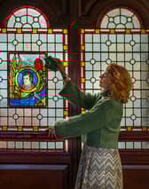 Fiona Lee is pictured with a stained glass window of Robert Burns inside St Michael's Church in Dumfries, which is seeking to raise £25,000 to protect and improve the building where the poet regularly attended Sunday service.
