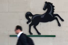 A man passes the entrance to a Lloyds Banking Group office in the City of London